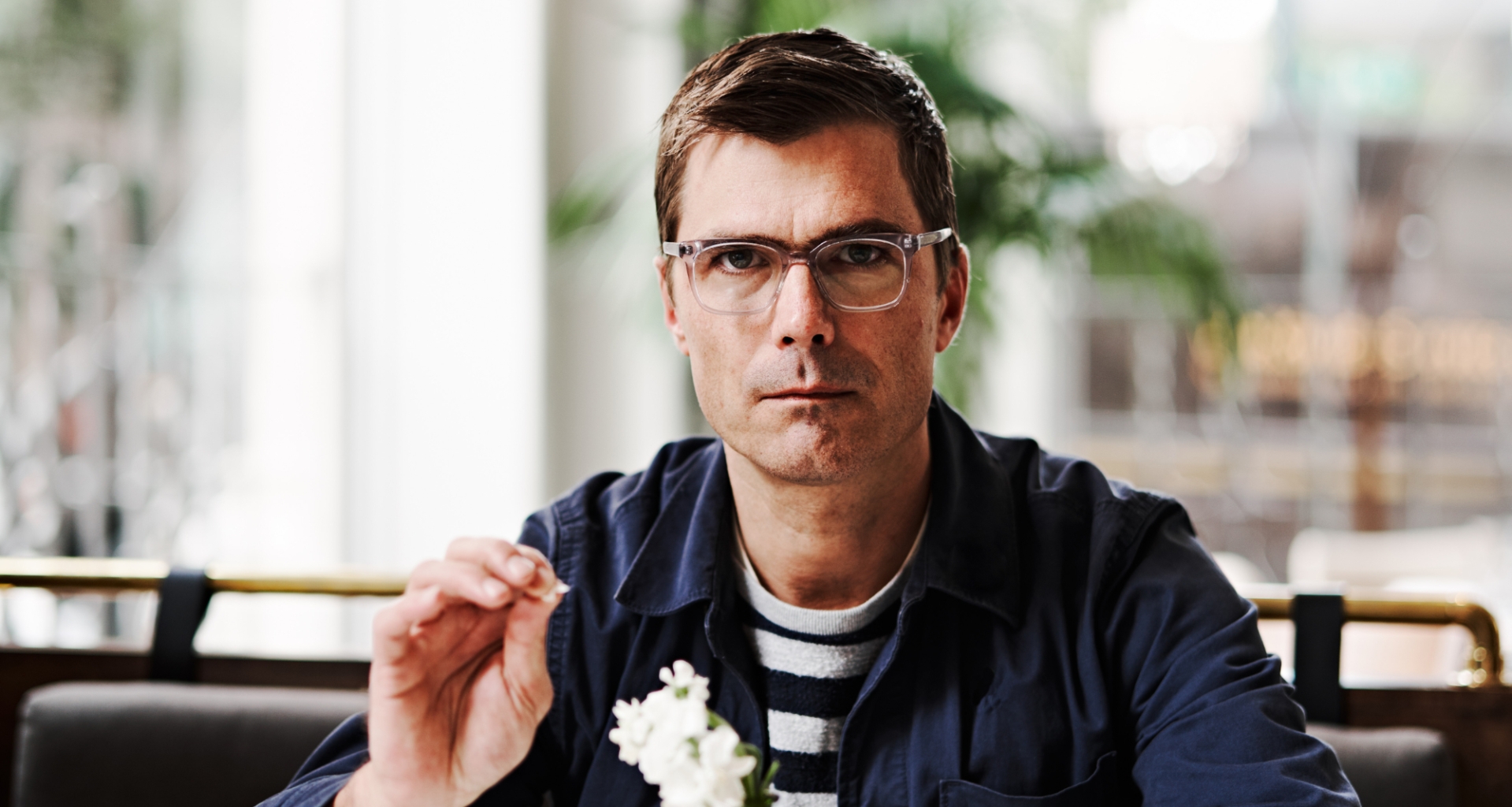 Chef Hugh Acheson holding a flower.